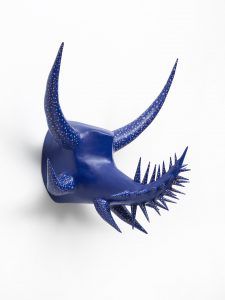 Horned sculpture made from paper and paint. Abstracted blue carnival/vejigante mask without eyeholes.