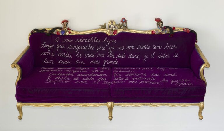 A royal purple velvet couch embroidered with a mother’s suicide note in white thread.