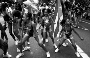 "Black and white photograph of dancers on Fifth Avenue during the National Puerto Rican Day parade in New York, New York." - Wanda Benvenutti