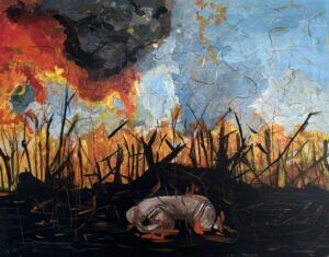 Fire burning grass around a figure on the ground with their head in their hands,