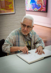 "This photo of Marcos Dimas was taken October 28, 2023 at Taller Boricua. I photographed Marcos sketching the band performing a jam session in the gallery." - Oliver Rios.