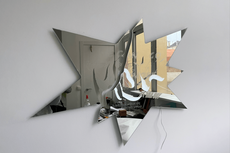 Mirror engraved and cut with wires dangling from behind the mount.