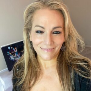 Artist Mariestella Colón Astacio, a woman with light colored hair, smiles.