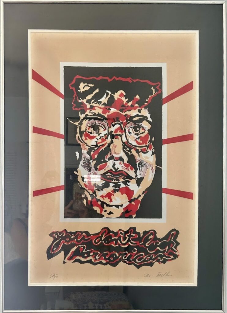 Print of Miguel Trelles wearing glasses with his face covered red and black splotches.