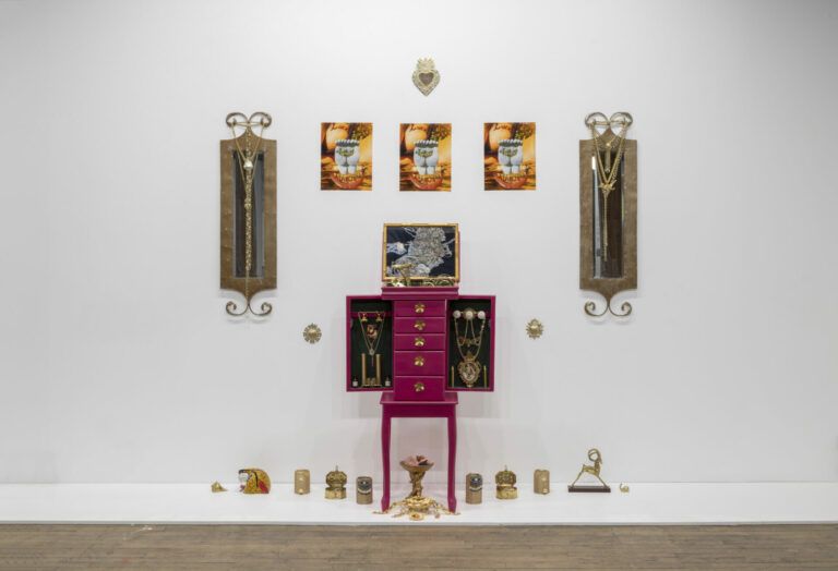 An altar of jewelry boxes and gold ornaments. At the very top there is a golden sacred heart.