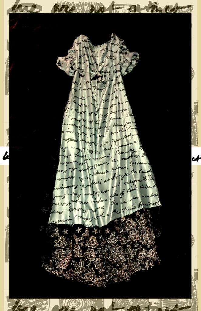A white dress patterned with text and lace.