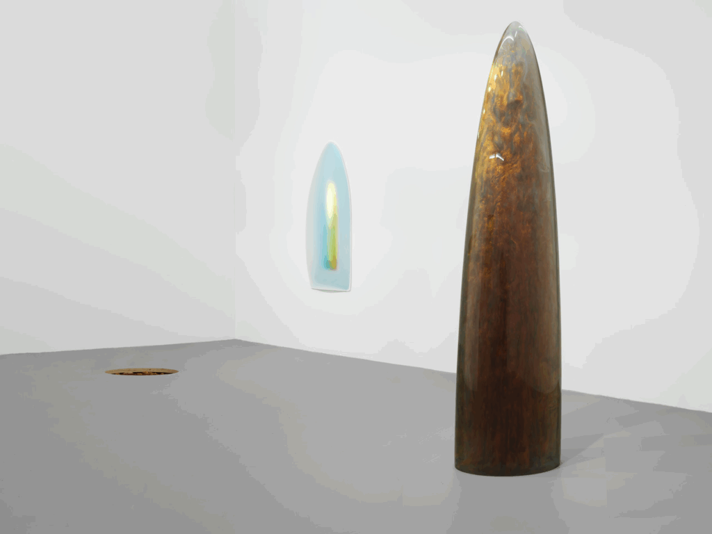 A tall rounded monolith made with shiny materials.