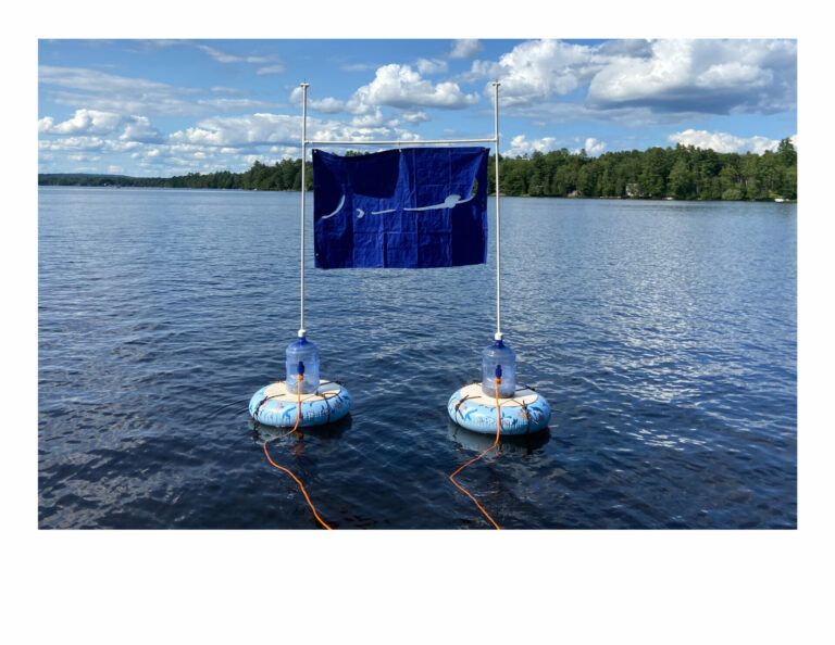 Floating apparatus holding up a blue tarp in a body of water.