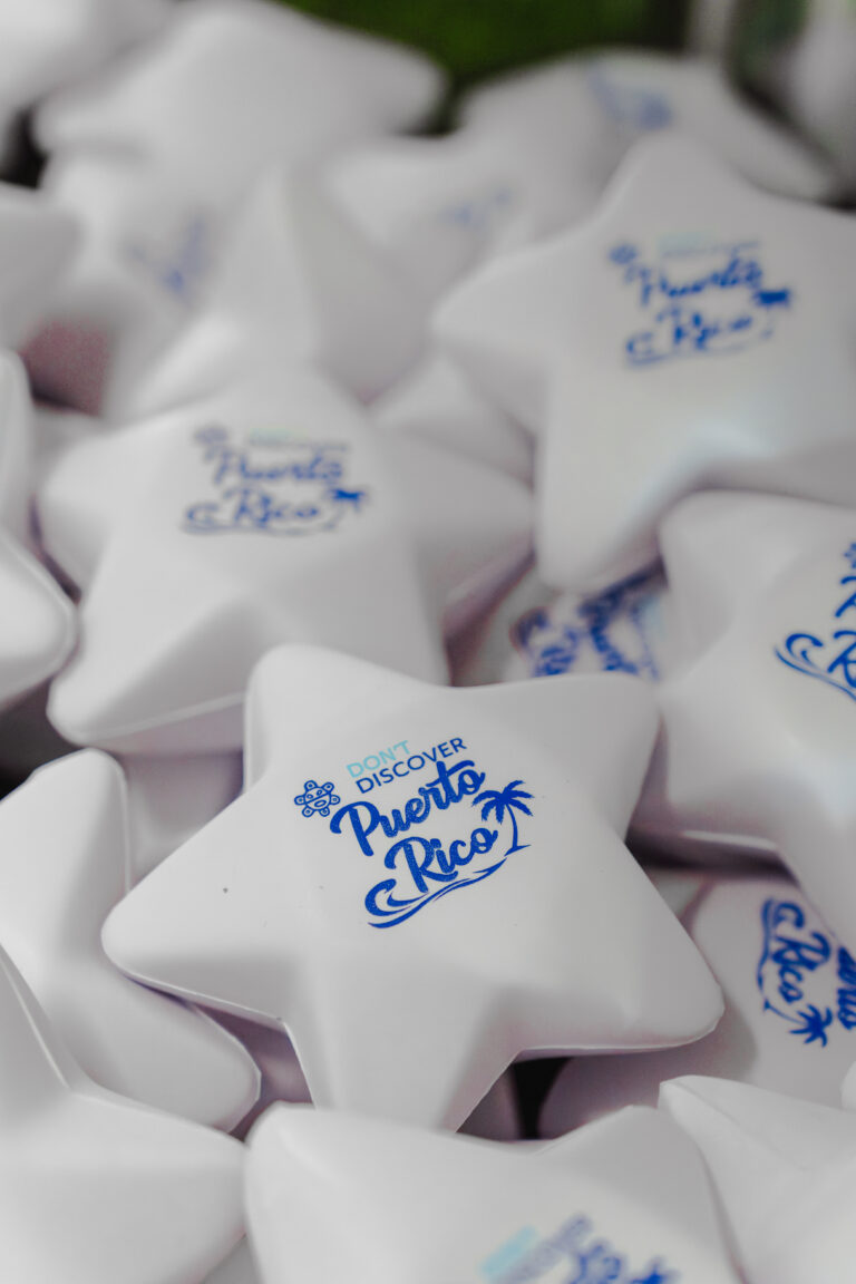 Win a Piece of Paradise! disguises itself as a claw machine, a game of chance wrapped in the kitsch aesthetics of a postcard. The surface reads Discover Puerto Rico, but graffiti reading DON’T interrupts the promise. Inside, souvenir stars act as tokens that recall how Puerto Rico and the Caribbean are packaged as a prize for outsiders. Above the machine, there’s a U.S. flag stripped of its stars.